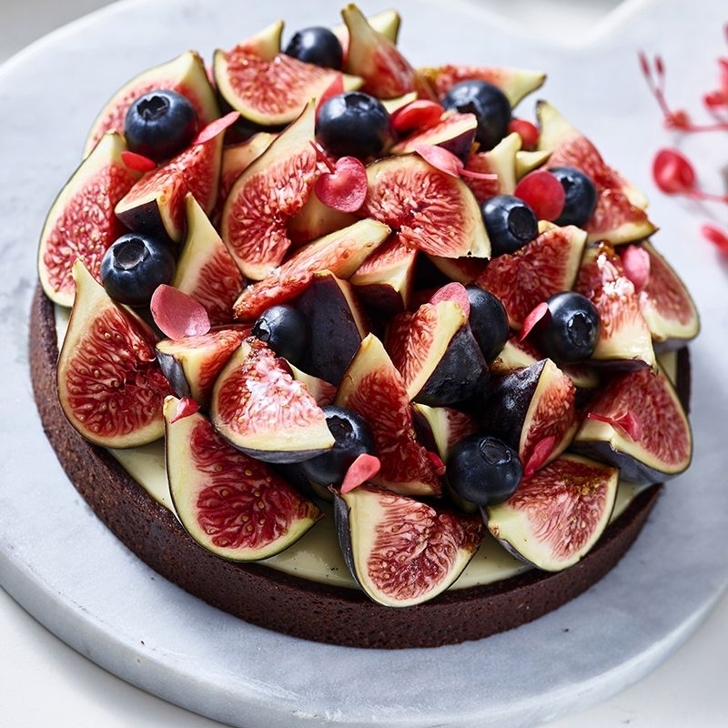 Chocolate cake topped with fresh figs and blueberries