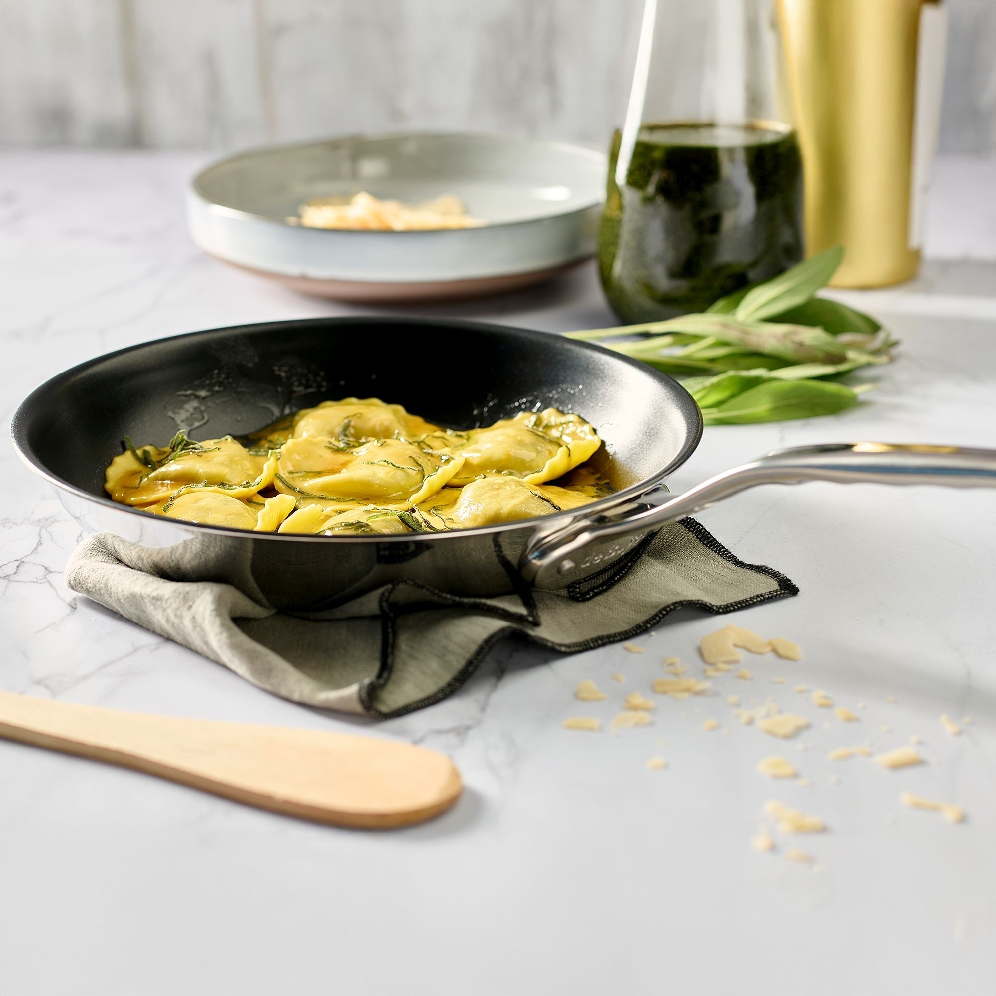 Frying pan with ravioli in sage butter on table