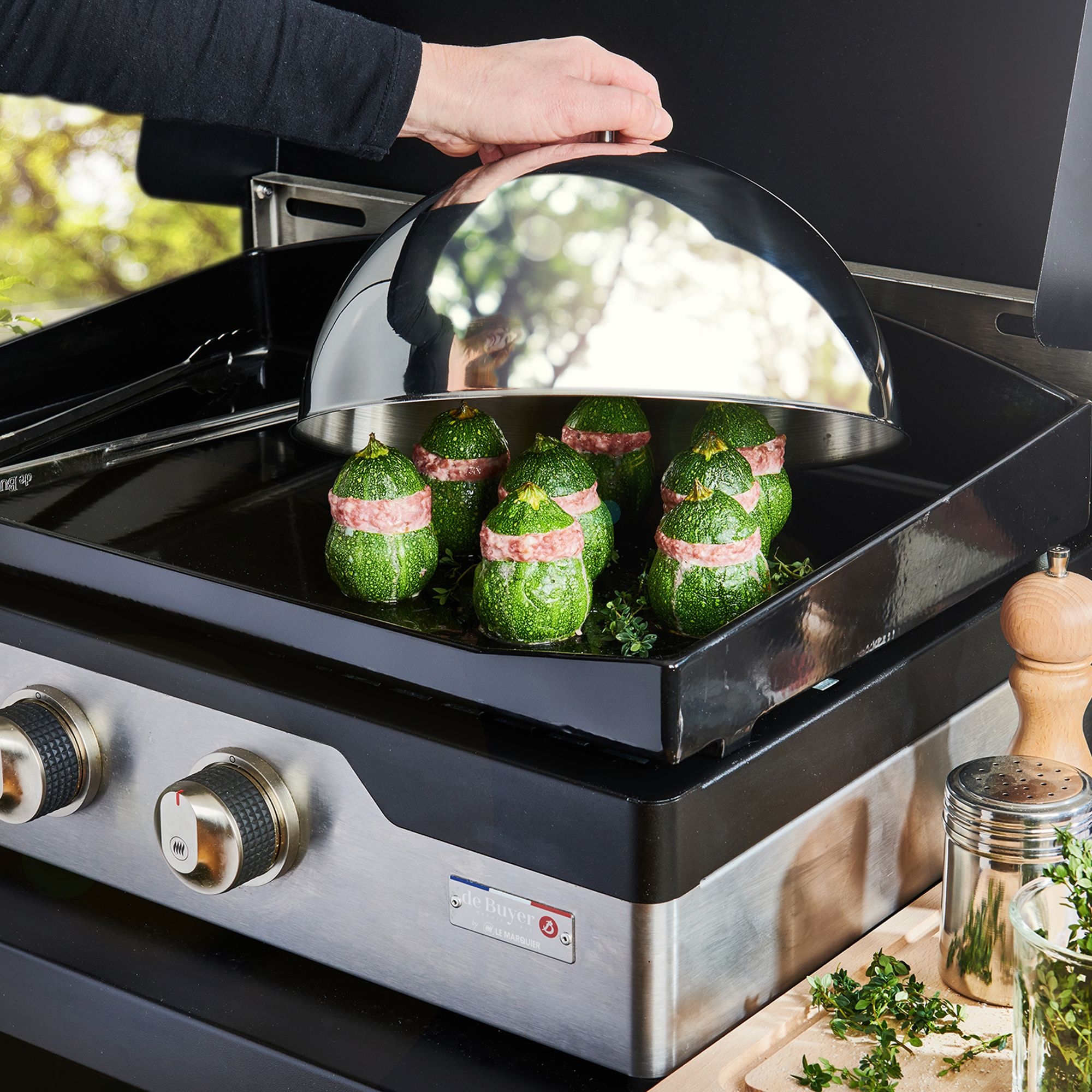 Gefüllte Zucchini unter Edelstahl-Glocke auf Plancha