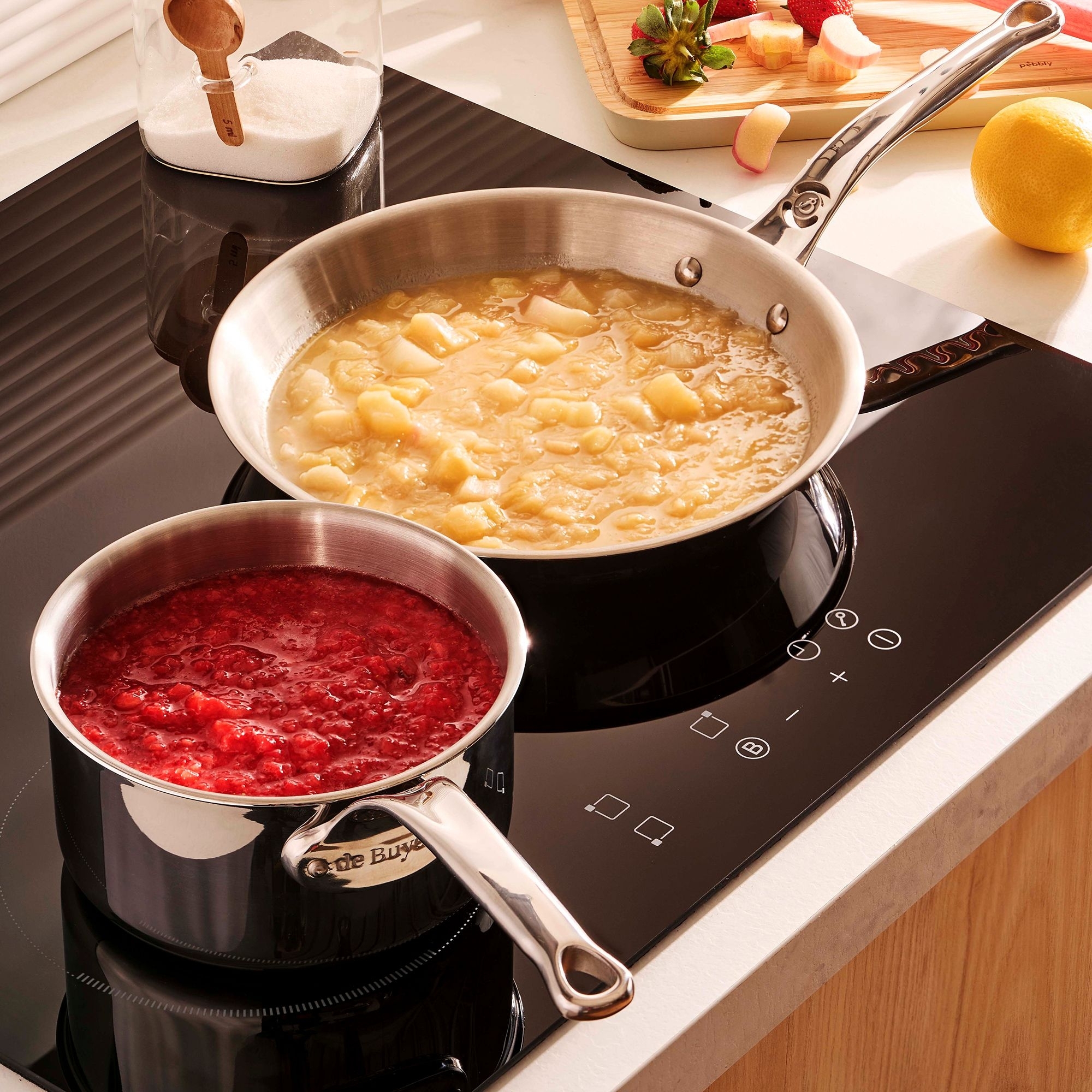 Stainless steel saucepans on black induction hob