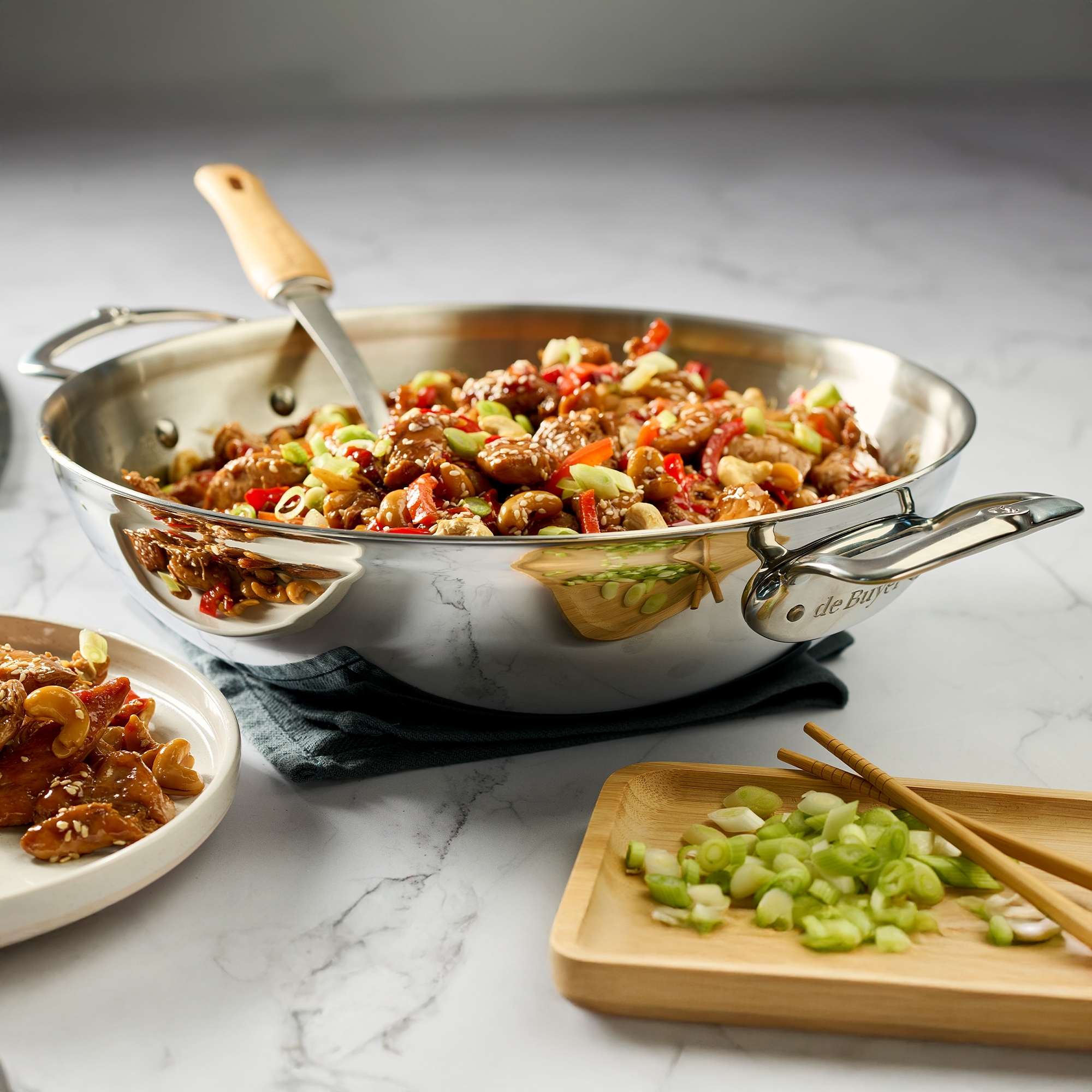 Gefüllte Edelstahl-Wokpfanne mit Gemüse, Nüssen und Hähnchen