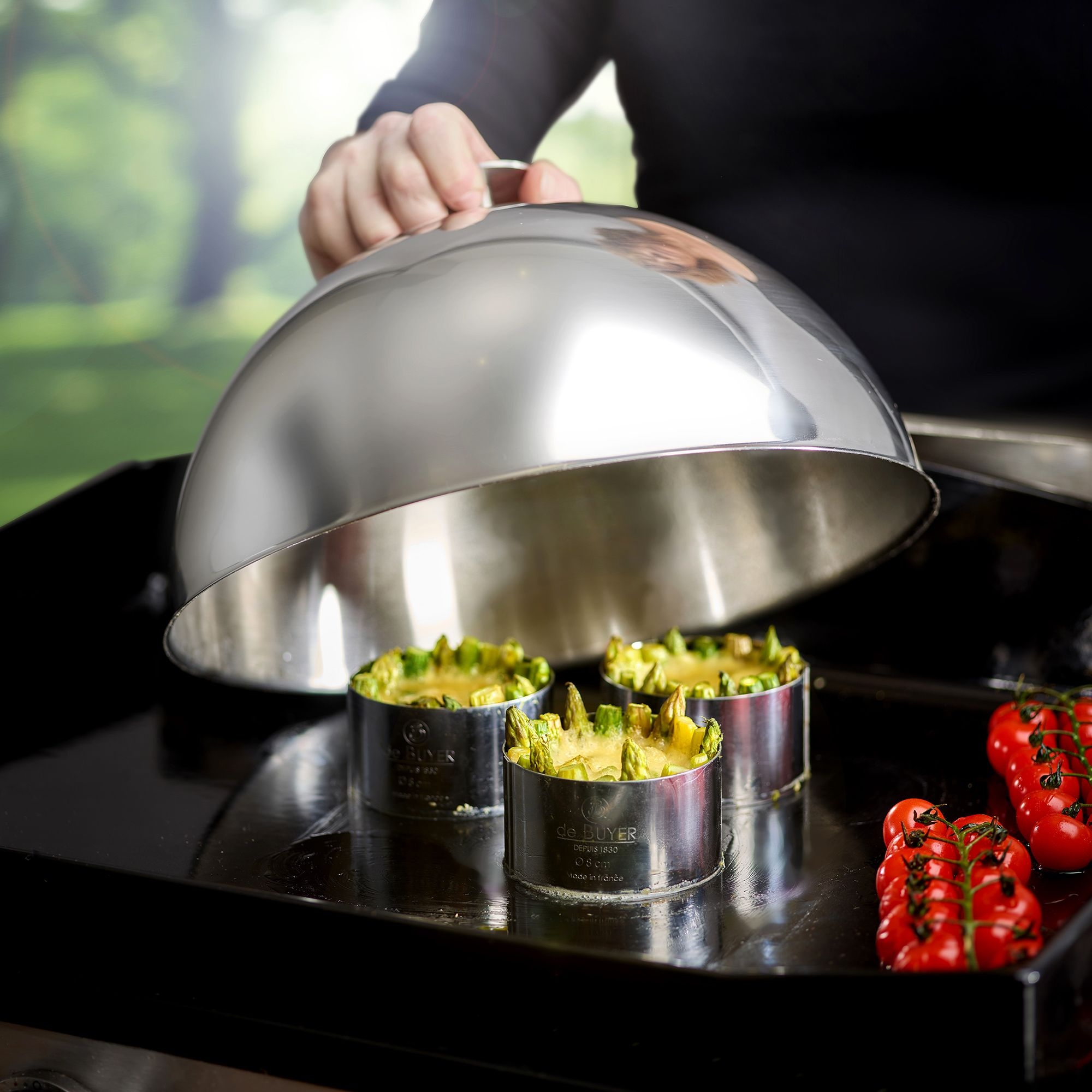 Edelstahl-Glocke deckt Gemüseformen und Tomaten auf Grill ab