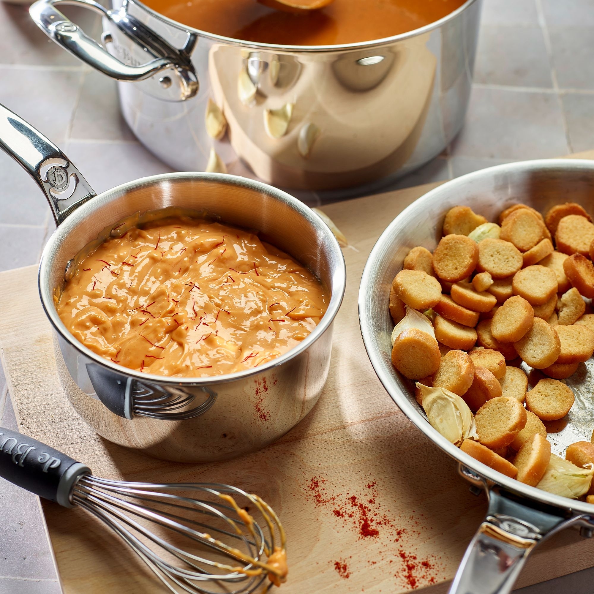 Stainless steel cookware with creamy sauce and croutons